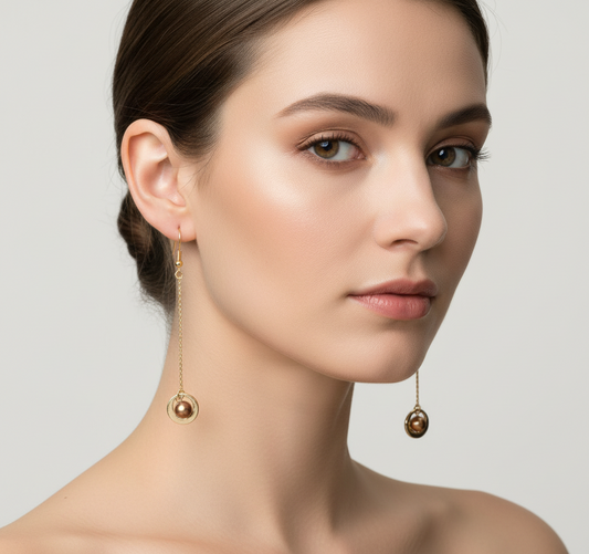 Woman wearing delicate gold drop earrings with freshwater pearls for an elegant look