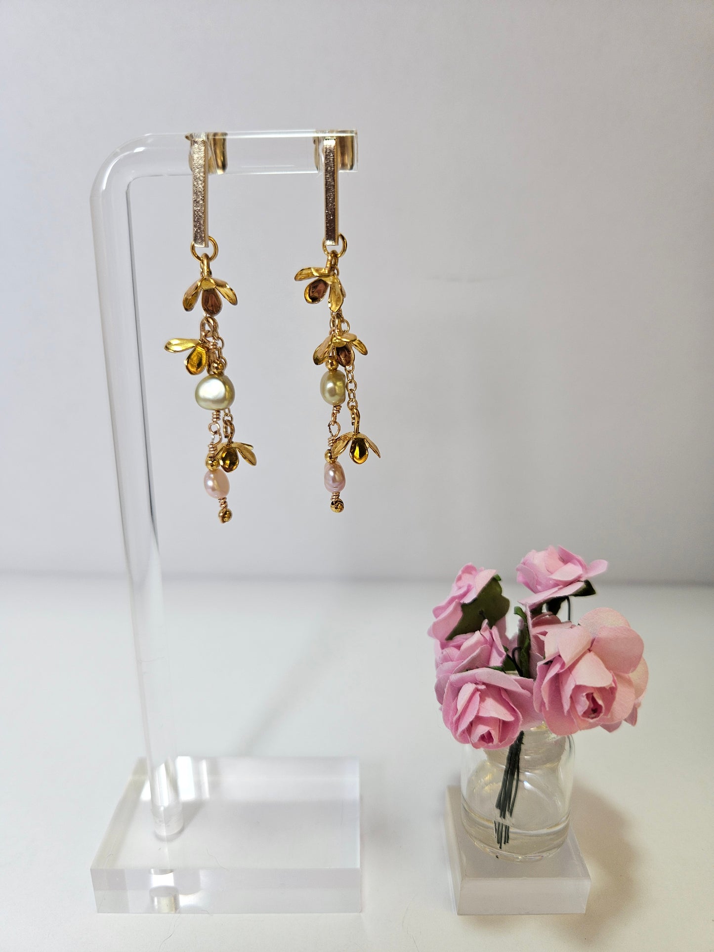golden pearl botanical dangle earrings on white background with pink roses