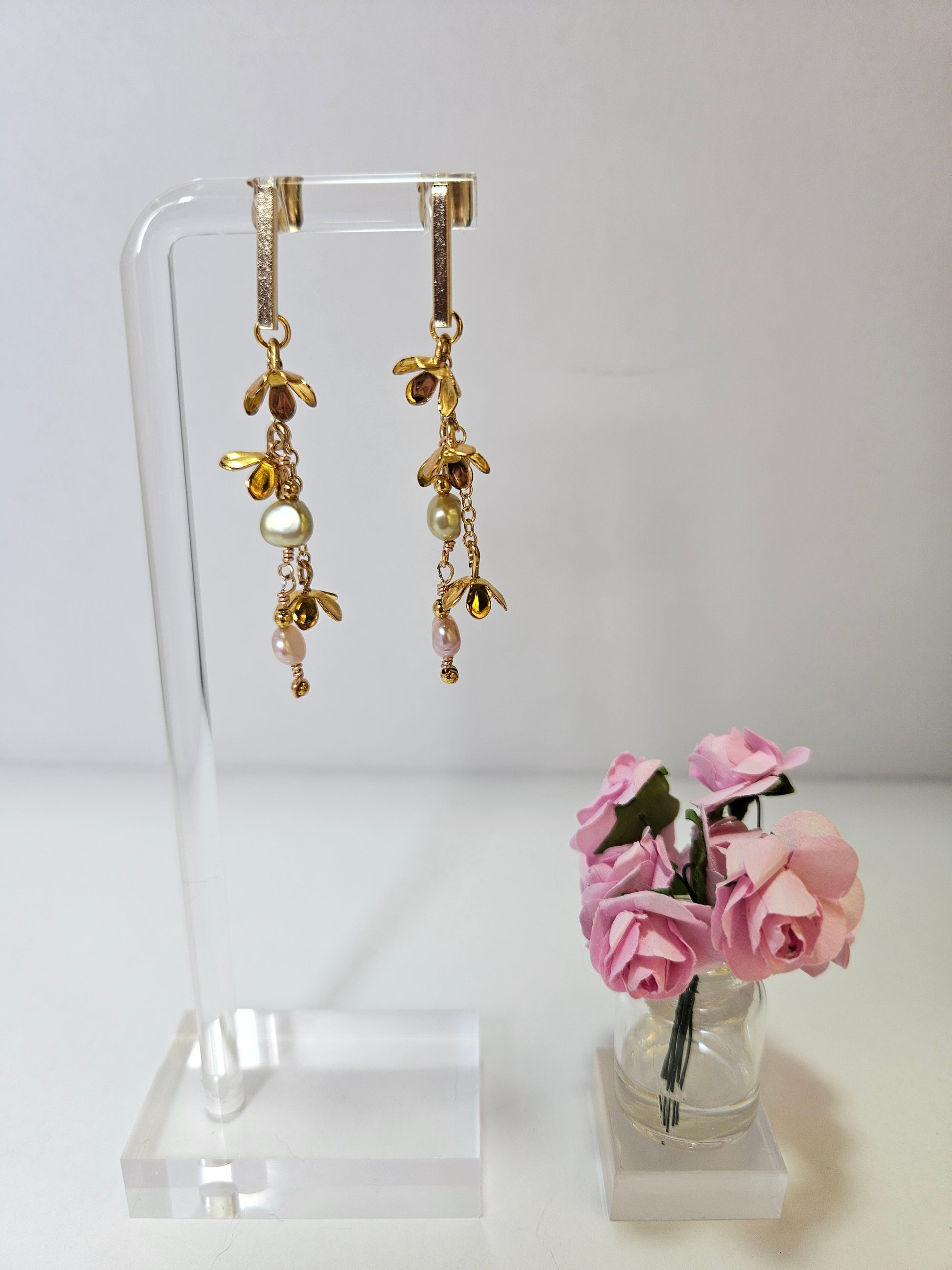 golden pearl botanical dangle earrings on white background with pink roses