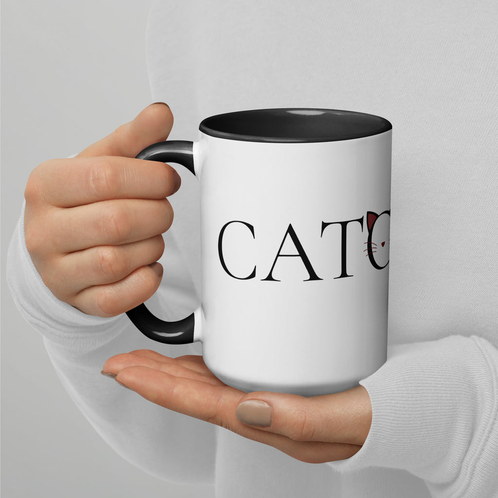 Person holding Catology mug with black handle close-up, drinking
